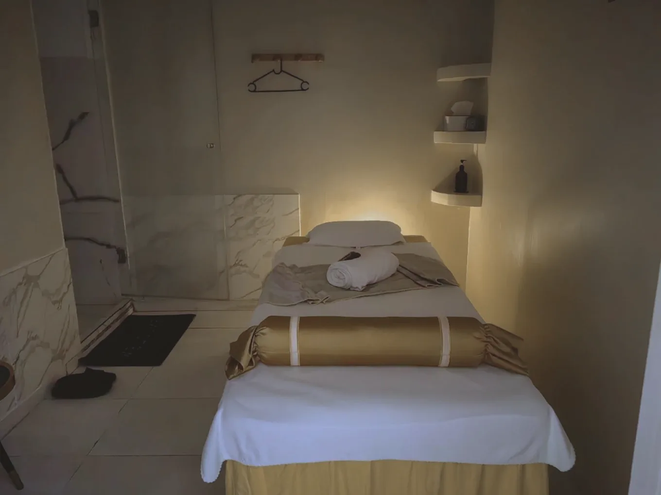 Cabine de soin du Spa Serenly baignée d'une lumière chaude, table de massage préparée
